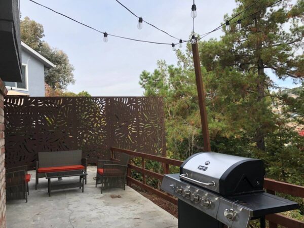 A grill on the patio of an outdoor room.