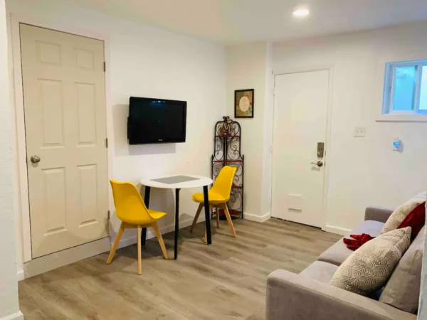 A room with a couch, table and two chairs.