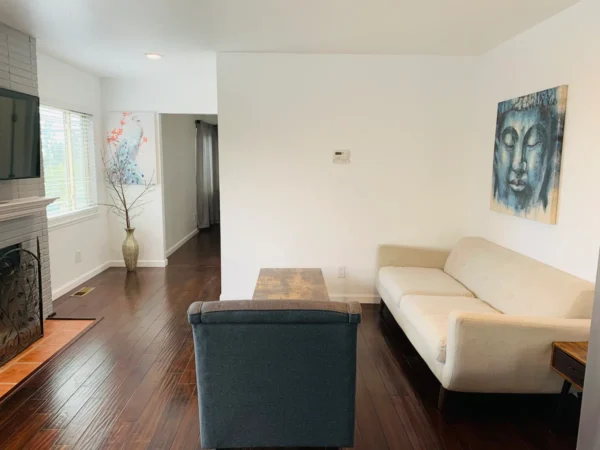 A living room with wood floors and white walls.