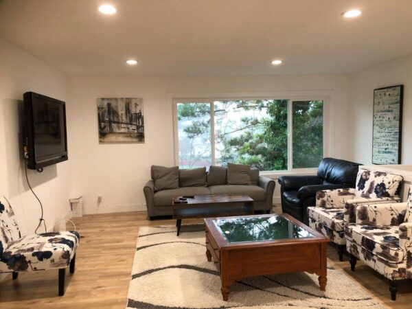 A living room with couches, chairs and tables.