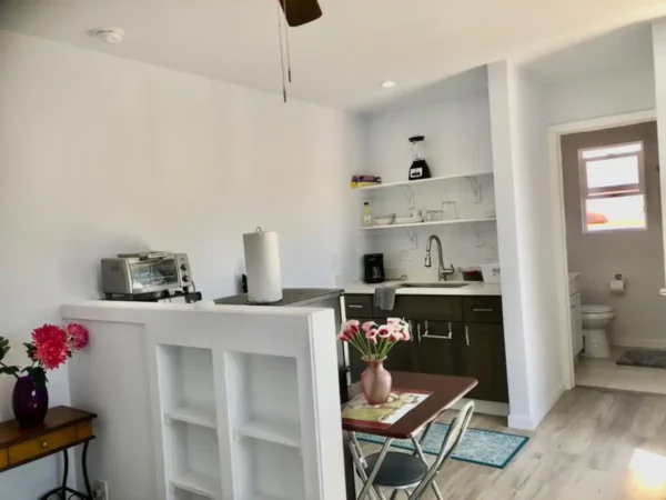 A kitchen with white walls and wooden floors.