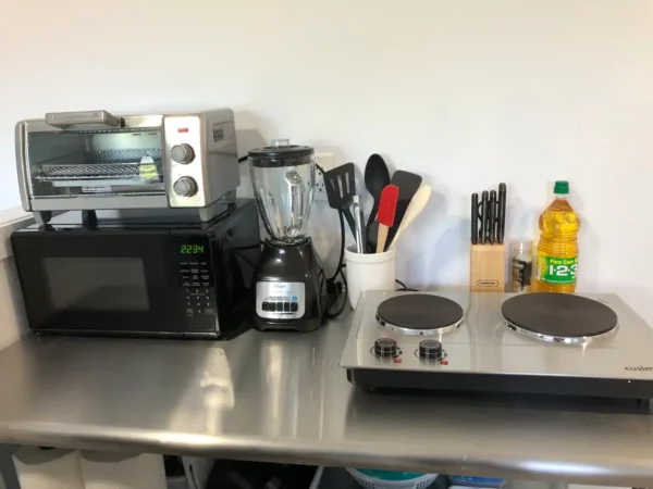 A kitchen counter with an electric stove and microwave.