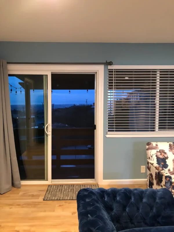 A living room with a couch and sliding glass door