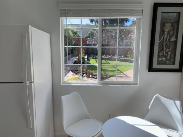 A white table and chairs in front of a window.