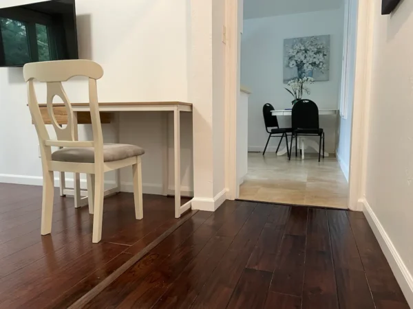 A room with wooden floors and white chairs.