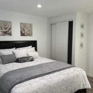 A bedroom with white walls and black furniture.