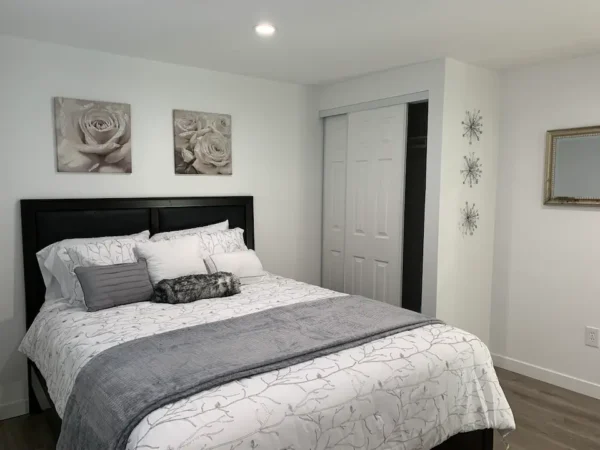 A bedroom with white walls and black furniture.