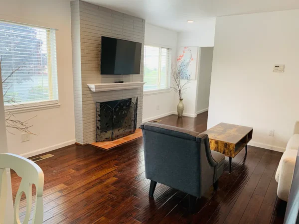 A living room with wood floors and fireplace.