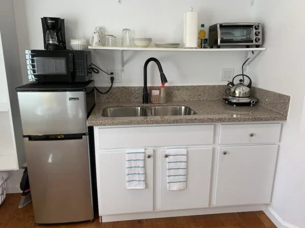 A kitchen with a sink, microwave and refrigerator.