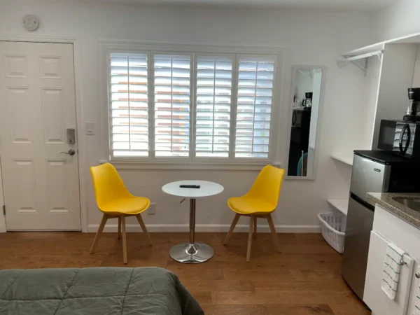 A room with two yellow chairs and a table