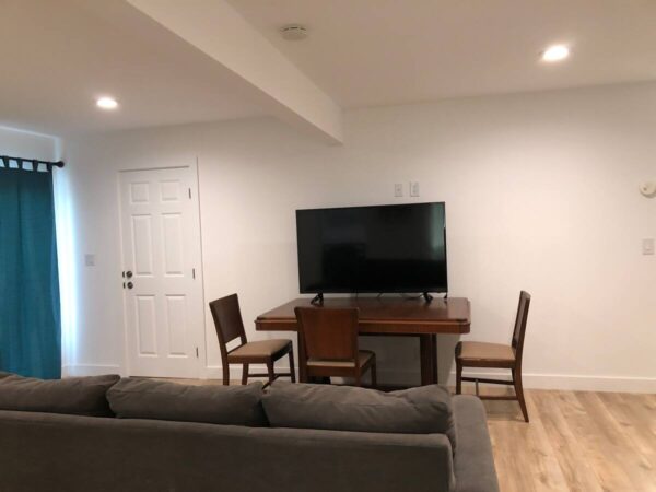 A living room with a couch, table and television.