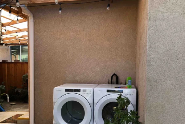 A couple of white washer and dryer in a room.