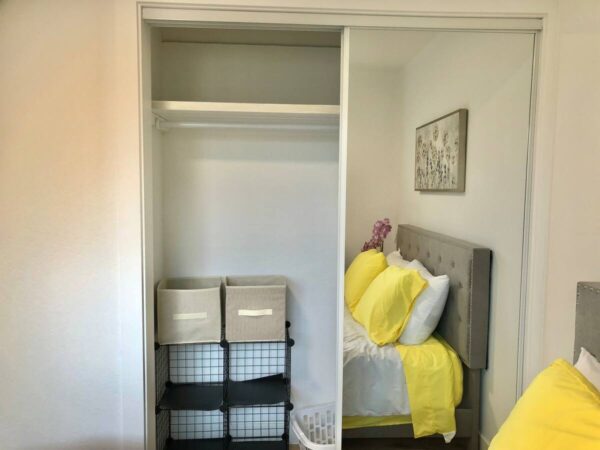 A bedroom with yellow sheets and pillows on the bed.