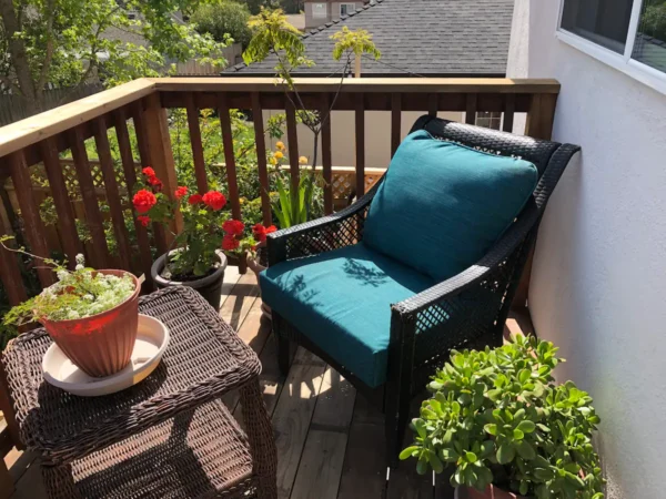 A blue chair on the back porch of a house.