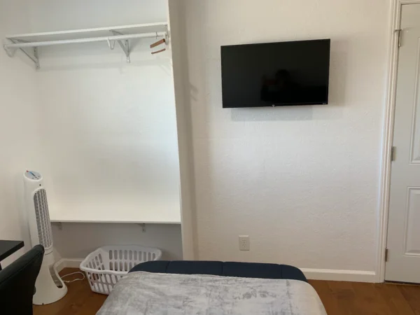 A bed room with a tv and a basket