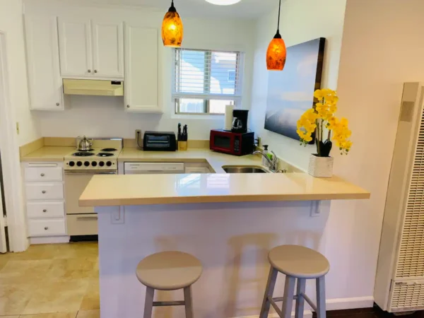 A kitchen with two stools and a microwave