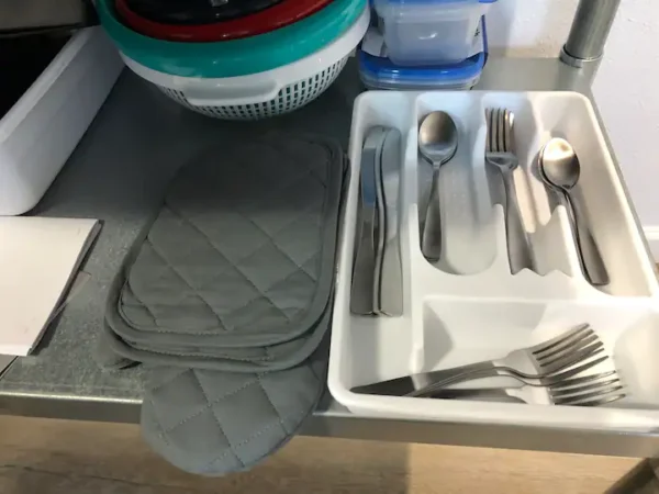 A kitchen counter with silverware and napkins.