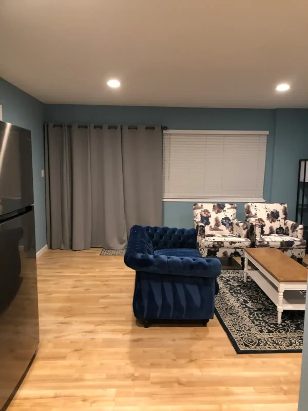 A living room with blue furniture and a television.