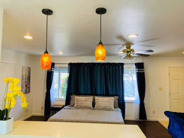 A bedroom with two lights hanging above the bed.