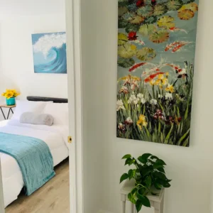 A bedroom with a bed and a painting on the wall