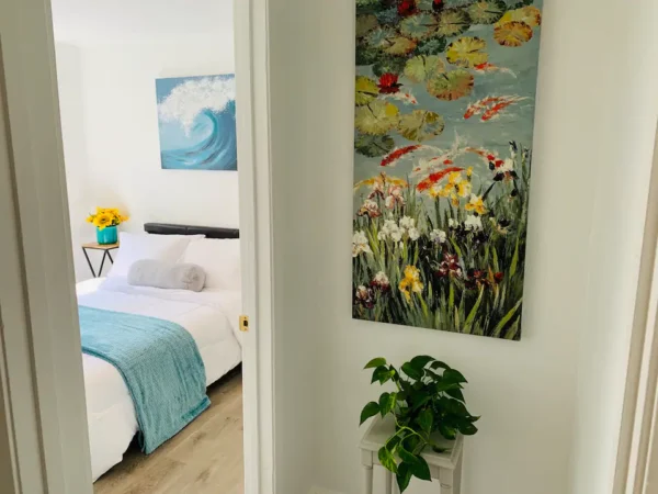 A bedroom with a bed and a painting on the wall