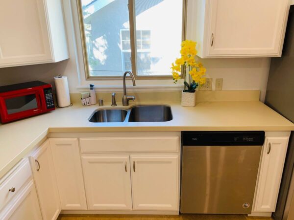 A kitchen with white cabinets and stainless steel appliances.