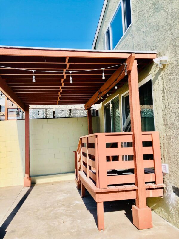 A wooden bench under an open roof.