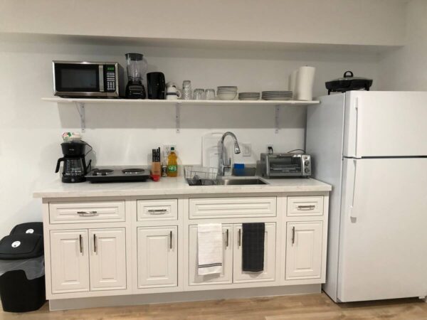 A kitchen with white cabinets and appliances in it.