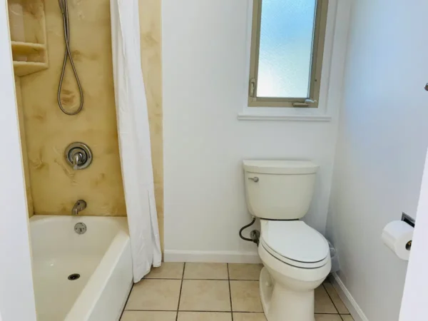 A bathroom with tile floors and walls.