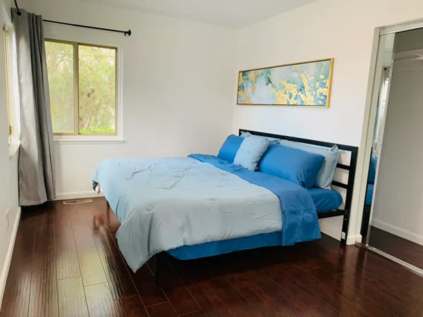 A bed room with a large blue bedspread