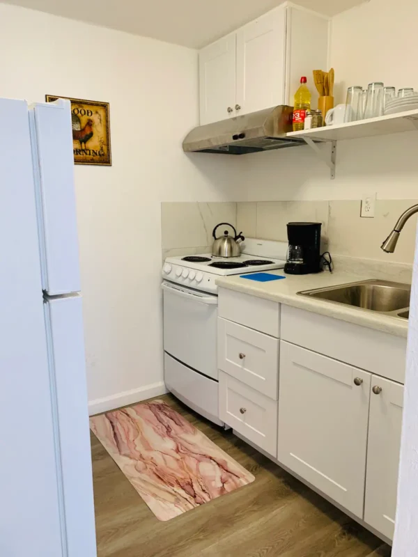 A kitchen with white cabinets and appliances.