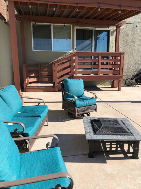 A patio with blue furniture and fire pit.