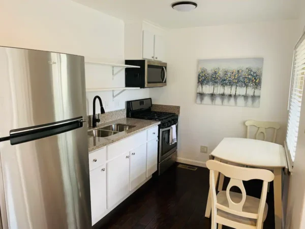 A kitchen with white cabinets and black floor