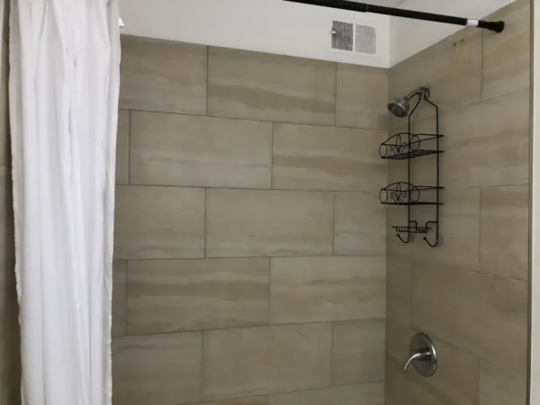 A bathroom with a shower and tiled walls.