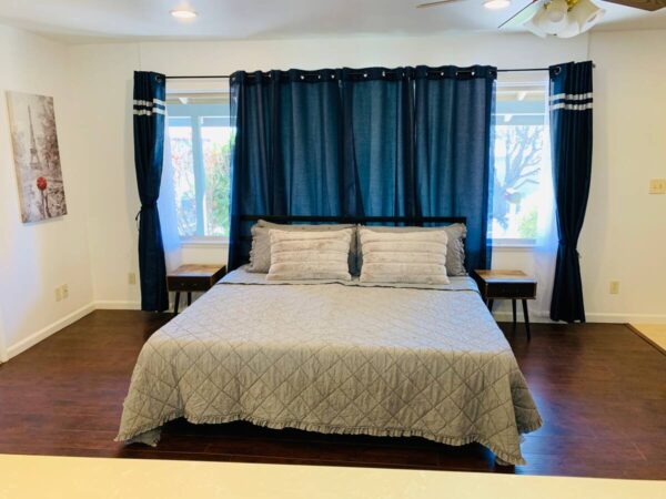 A bed room with a blue bedspread and curtains