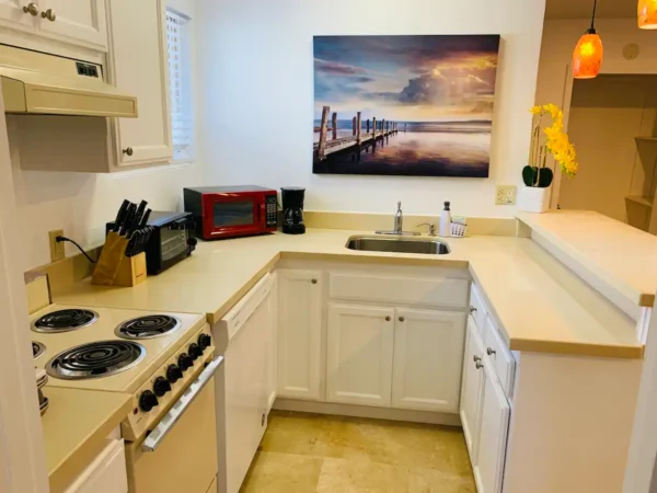 A kitchen with white cabinets and a microwave.