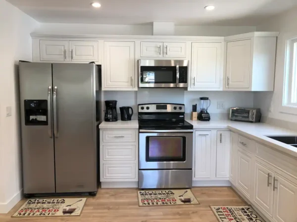 A kitchen with white cabinets and stainless steel appliances.