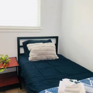 A small bed in a room with a window.