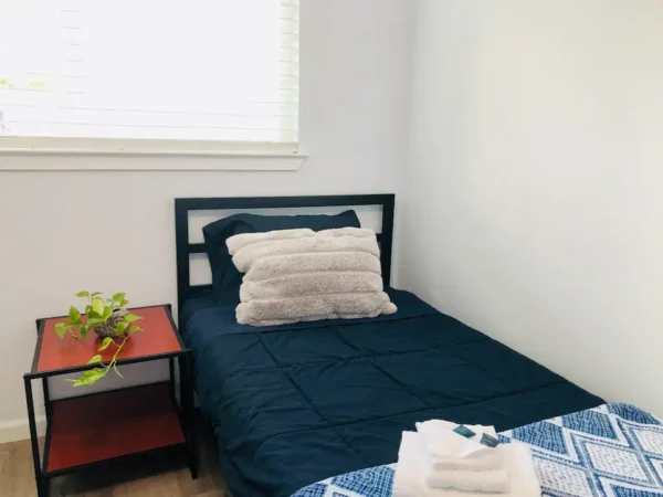 A small bed in a room with a window.