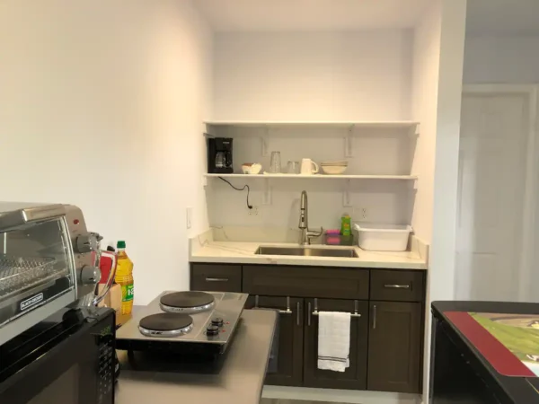 A kitchen with a stove, sink and counter.