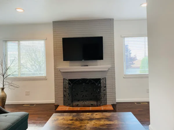 A living room with a fireplace and a flat screen tv.