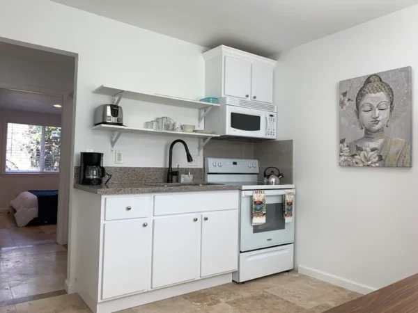 A kitchen with white cabinets and appliances in it