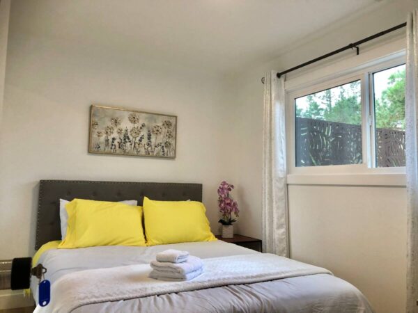 A bed room with a white bed and yellow pillows