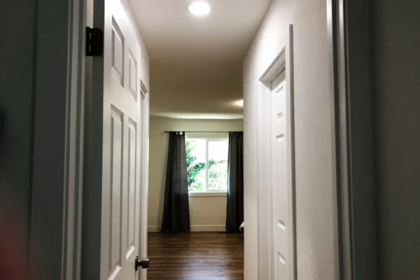 A hallway with two doors and a window.