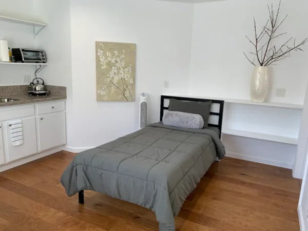 A bed room with a single bed and a cabinet