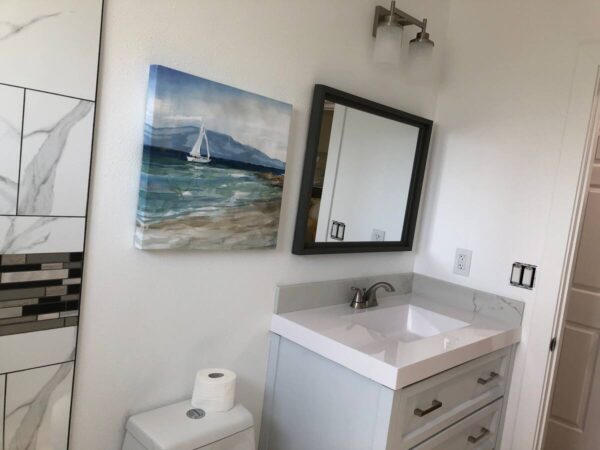 A bathroom with a sink, mirror and toilet.