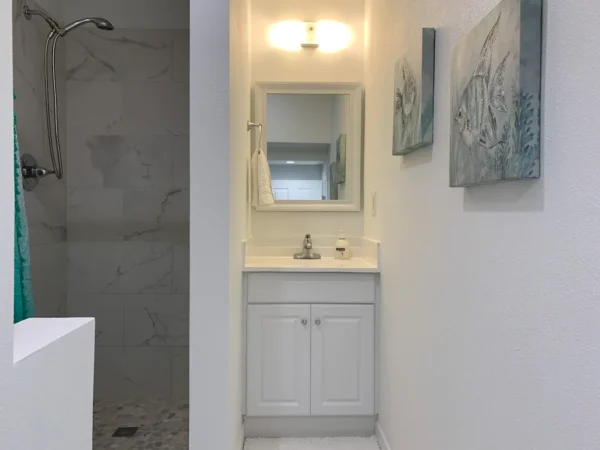 A bathroom with white walls and a sink.