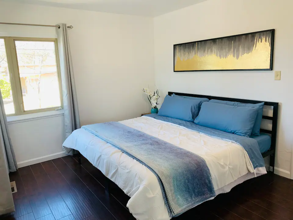 A bedroom with a large bed and wooden floors