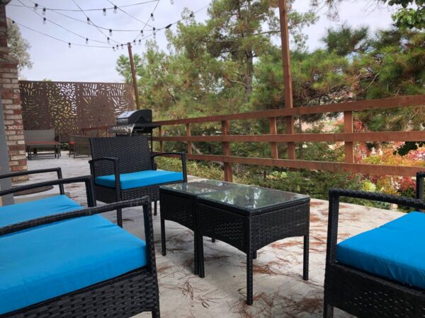 A patio with blue chairs and tables on the ground.