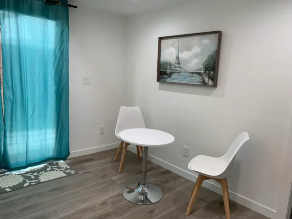 A room with two white chairs and a table